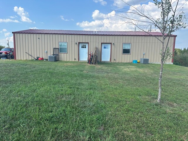 view of outbuilding featuring central air condition unit and a lawn