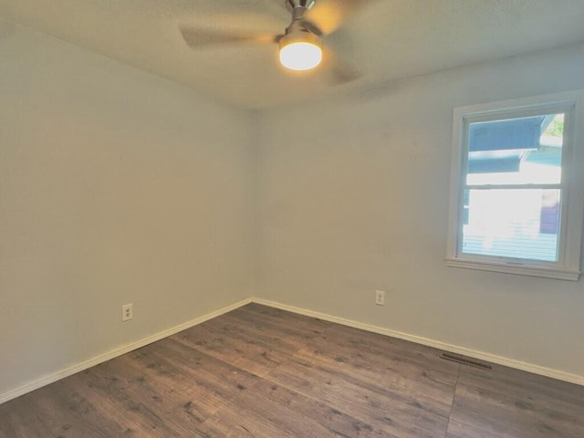 unfurnished room with ceiling fan and dark wood-type flooring