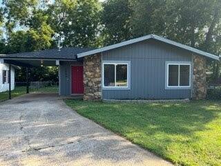 single story home with a carport and a front lawn