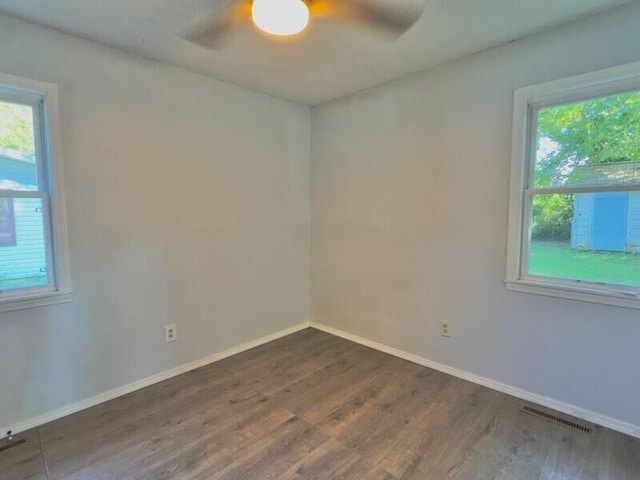 spare room with dark hardwood / wood-style flooring and ceiling fan