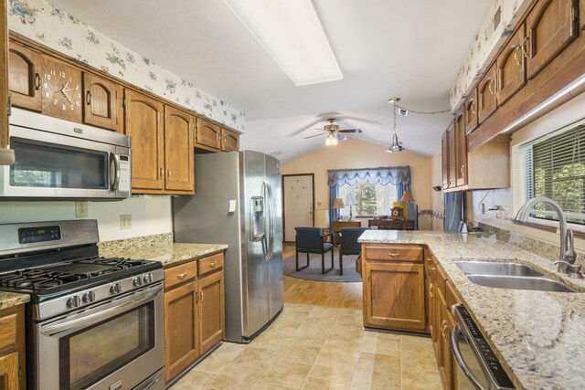 kitchen with light wood-type flooring, sink, lofted ceiling, kitchen peninsula, and appliances with stainless steel finishes