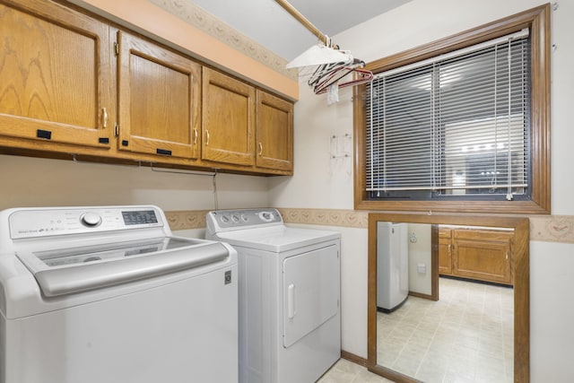 clothes washing area featuring cabinets and washer and dryer