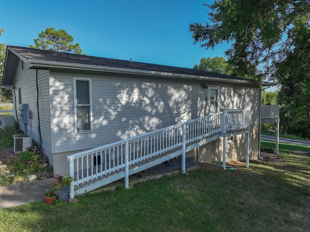 back of house featuring a yard, a wooden deck, and central AC unit