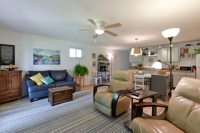 living room featuring ceiling fan and hardwood / wood-style floors