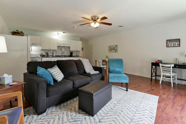 living room with sink, dark wood-type flooring, and ceiling fan