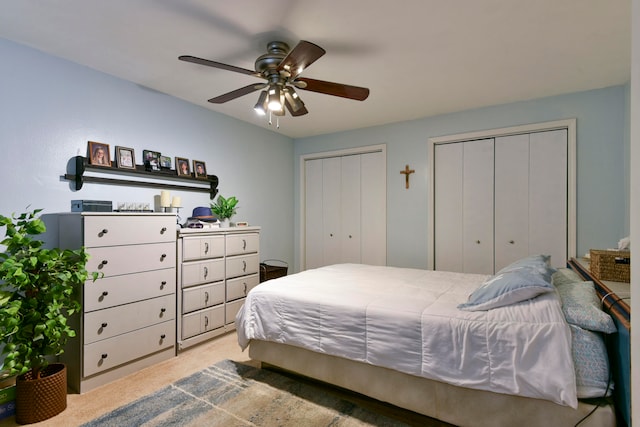 carpeted bedroom with two closets and ceiling fan