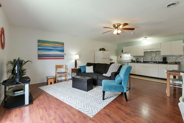 living room with ceiling fan, sink, and dark hardwood / wood-style flooring