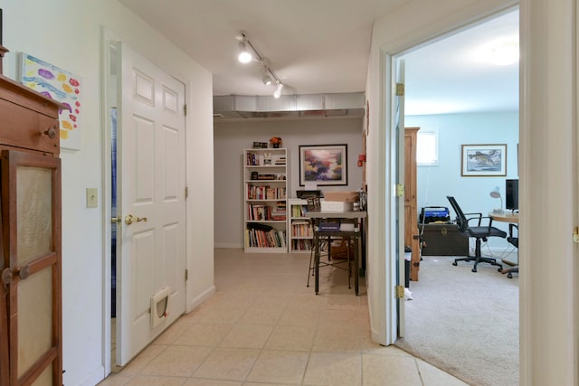 hallway with rail lighting and light colored carpet