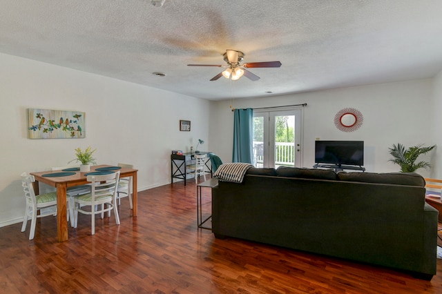 living room with ceiling fan, a textured ceiling, and dark hardwood / wood-style flooring