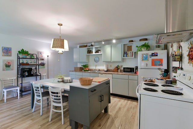 kitchen with white appliances, light wood-type flooring, a kitchen island, pendant lighting, and exhaust hood