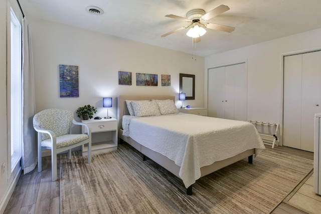 22016 Waters Edge Dr, Shell Knob, MO 65747 - bedroom with light wood finished floors, ceiling fan, visible vents, and two closets