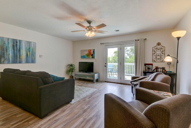 living room featuring light hardwood / wood-style floors and ceiling fan