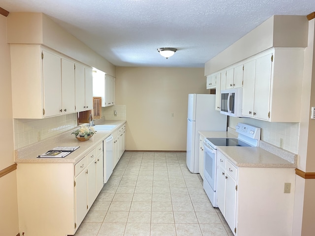 kitchen with sink, white appliances, white cabinetry, and backsplash