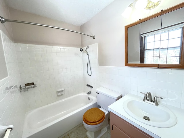 full bathroom featuring vanity, tile patterned flooring, tiled shower / bath combo, toilet, and tile walls