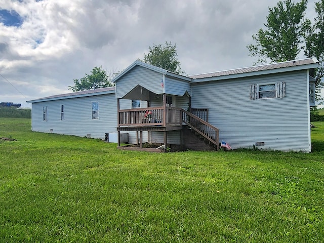 back of house featuring a deck and a lawn