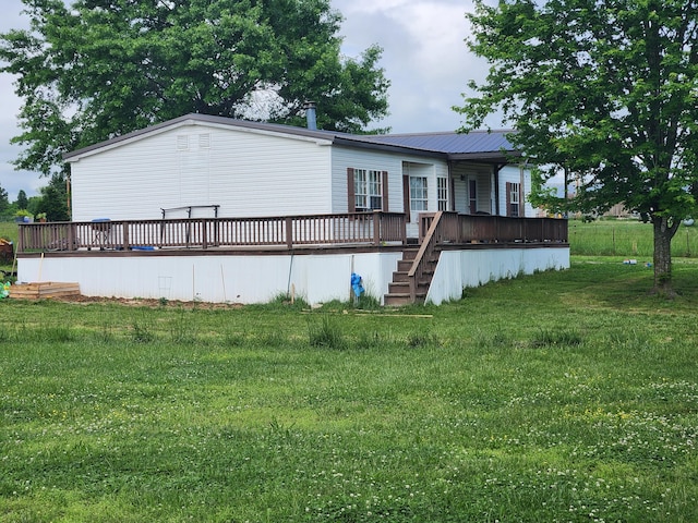 rear view of property with a yard and a wooden deck