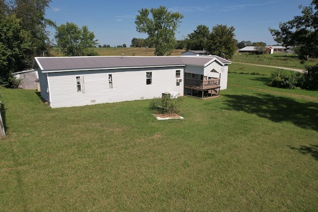 rear view of house with a deck and a yard