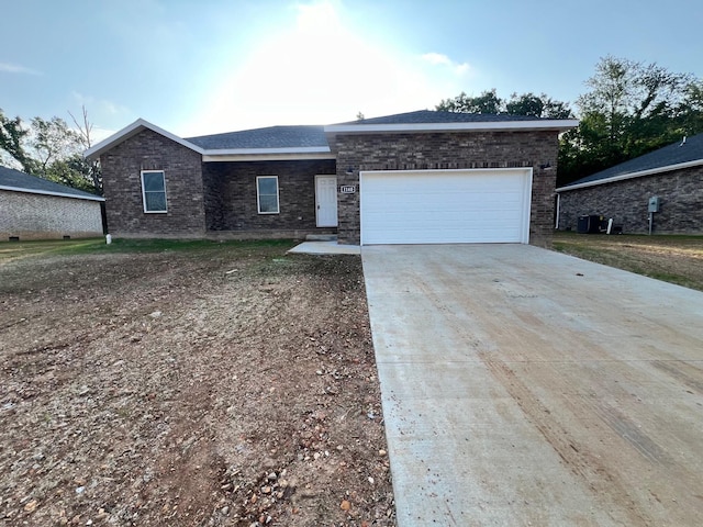 ranch-style home with brick siding, an attached garage, and driveway