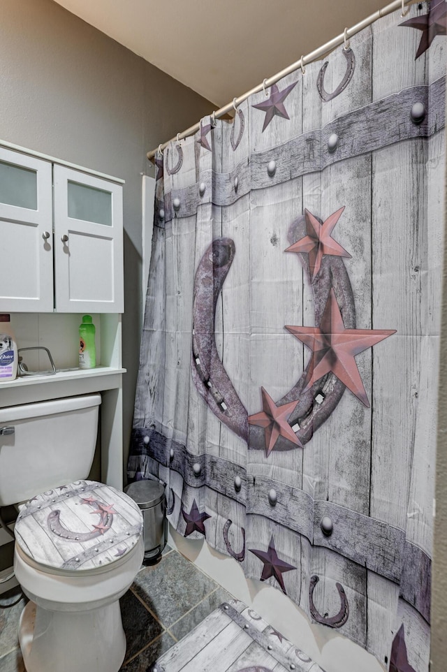 bathroom with toilet and a shower with shower curtain