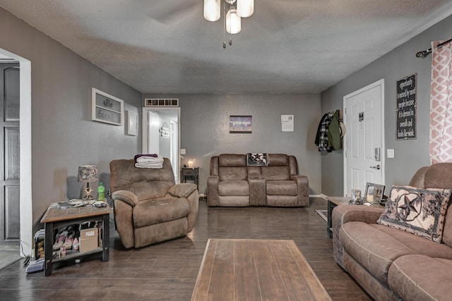 living area with a ceiling fan, visible vents, a textured ceiling, and dark wood finished floors