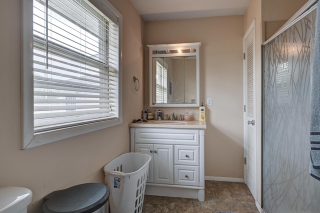 full bath featuring a shower stall, toilet, vanity, and baseboards