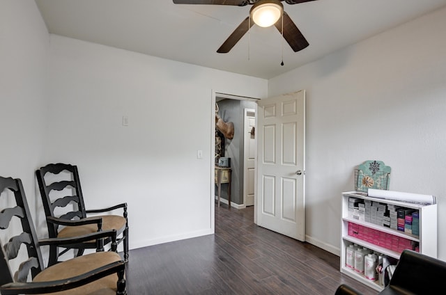 sitting room with ceiling fan, baseboards, and dark wood-type flooring