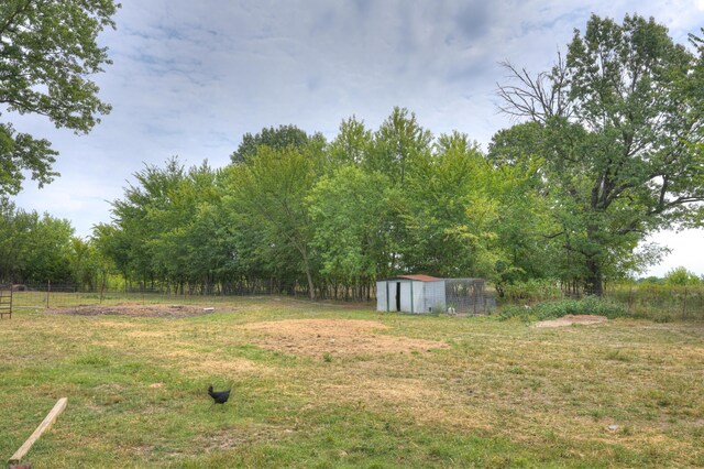view of yard featuring fence, an outbuilding, and a storage shed