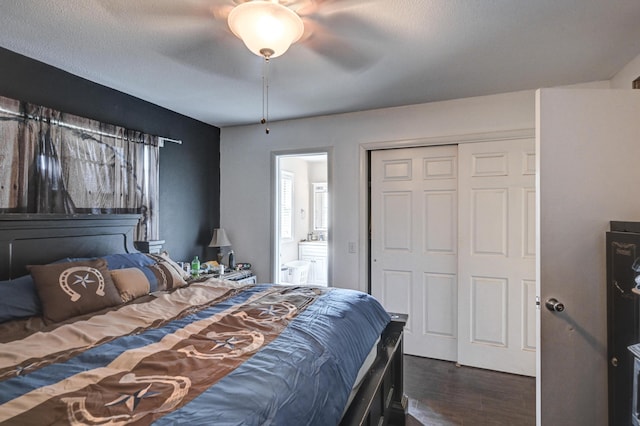 bedroom with ceiling fan, dark wood-type flooring, a closet, connected bathroom, and a textured ceiling