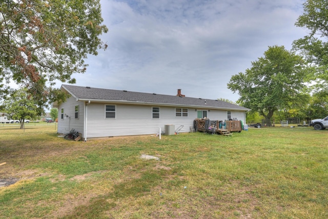 rear view of house with a wooden deck, a chimney, a yard, and central air condition unit