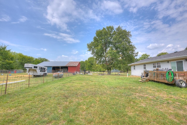 view of yard with fence, an outdoor structure, and an outbuilding