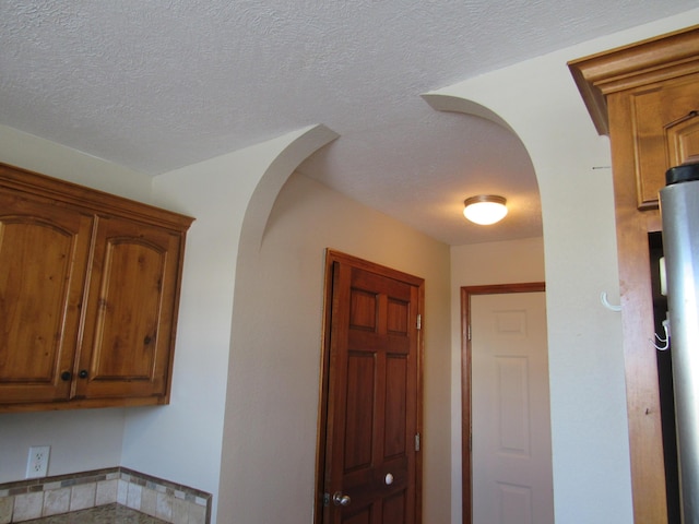 hallway with a textured ceiling