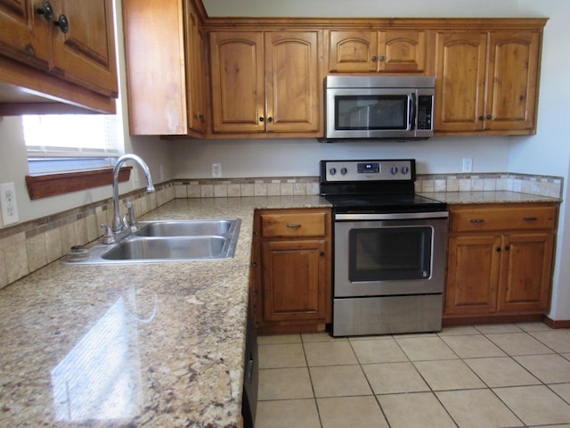 kitchen featuring sink, light tile patterned floors, and stainless steel appliances