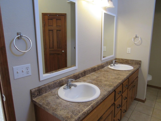 bathroom with tile patterned flooring, vanity, and toilet