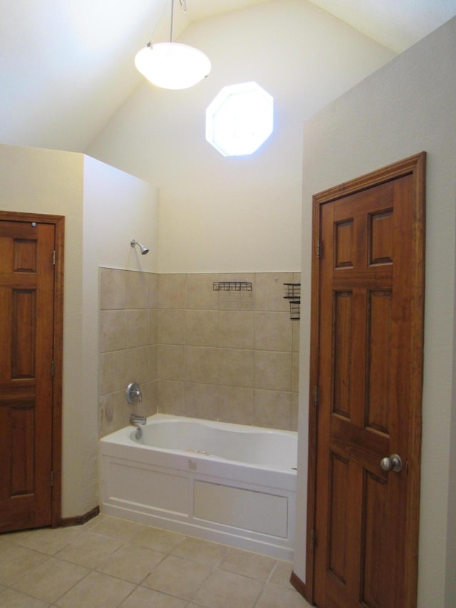 bathroom with a bathing tub, tile patterned flooring, and vaulted ceiling