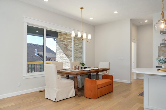 dining area featuring a chandelier and light wood-type flooring