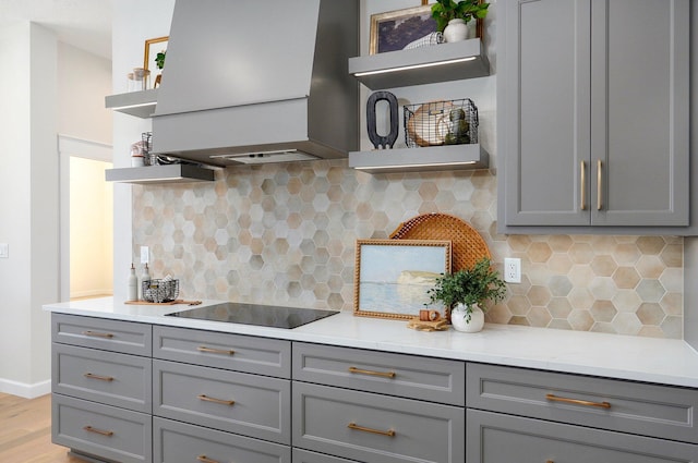 kitchen with light wood-type flooring, exhaust hood, black electric cooktop, and gray cabinets