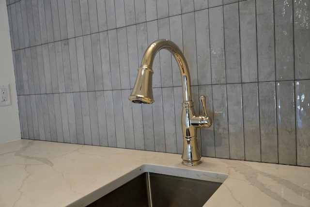 room details featuring light stone countertops and sink