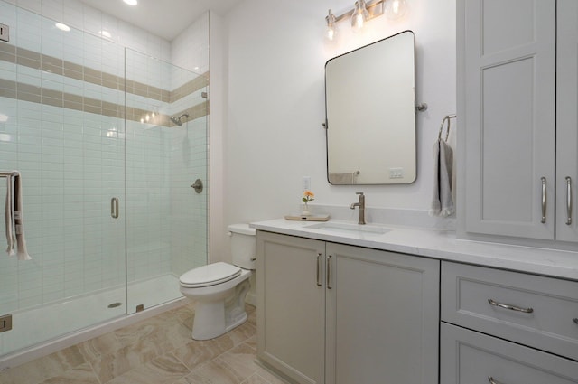 bathroom featuring vanity, toilet, and a shower with shower door