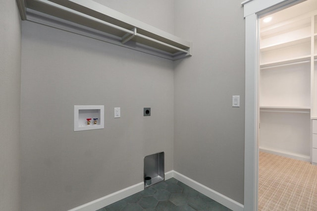 laundry area featuring electric dryer hookup, washer hookup, and dark tile patterned floors