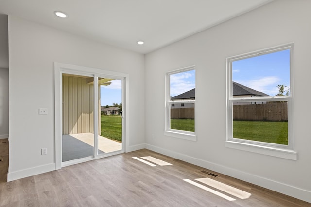 spare room with baseboards, wood finished floors, visible vents, and recessed lighting