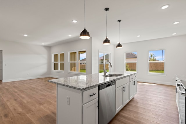 kitchen with light hardwood / wood-style floors, decorative light fixtures, sink, dishwasher, and white cabinetry