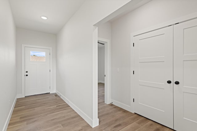 doorway to outside featuring baseboards and light wood-style floors