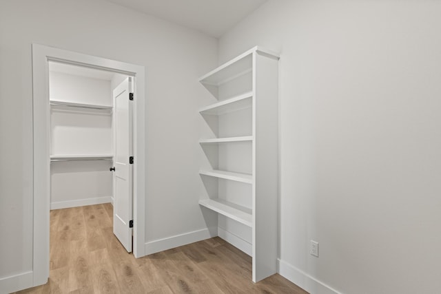 walk in closet featuring light wood finished floors