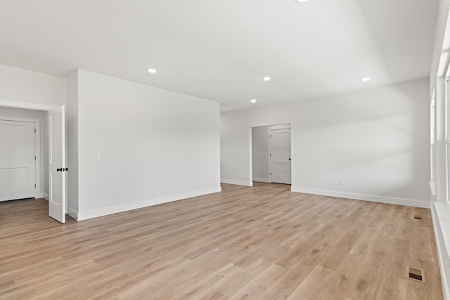 spare room featuring light wood finished floors, baseboards, visible vents, and recessed lighting