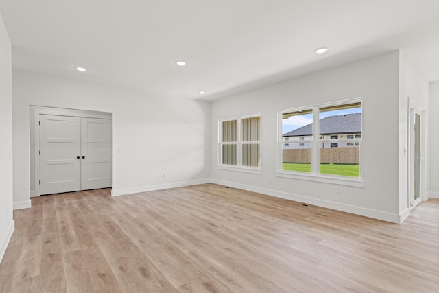 empty room with recessed lighting, light wood-type flooring, and baseboards