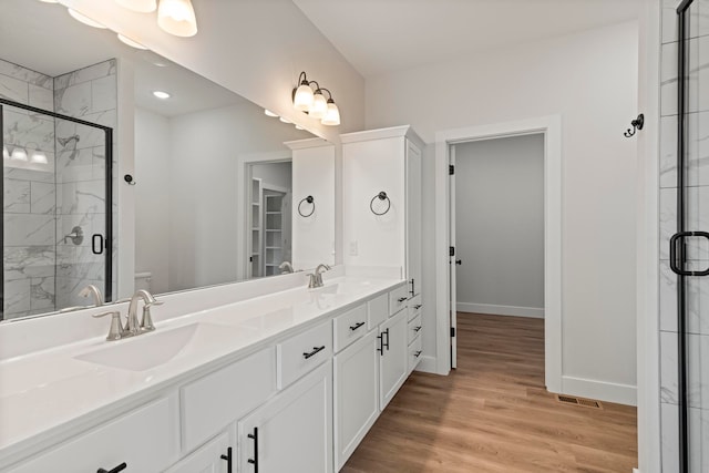 bathroom with walk in shower, hardwood / wood-style flooring, vanity, and toilet