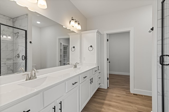 bathroom featuring baseboards, a stall shower, and a sink