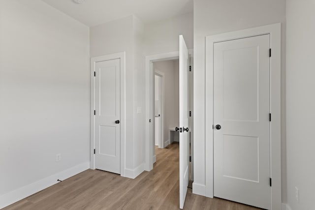 unfurnished bedroom featuring light wood-style flooring and baseboards
