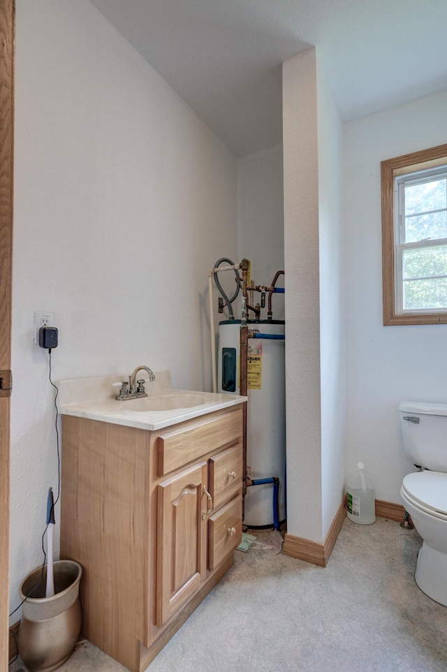 bathroom featuring water heater, vanity, and toilet