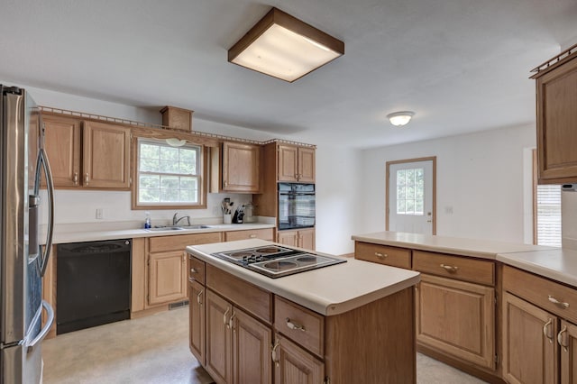 kitchen featuring plenty of natural light, black appliances, a kitchen island, and sink